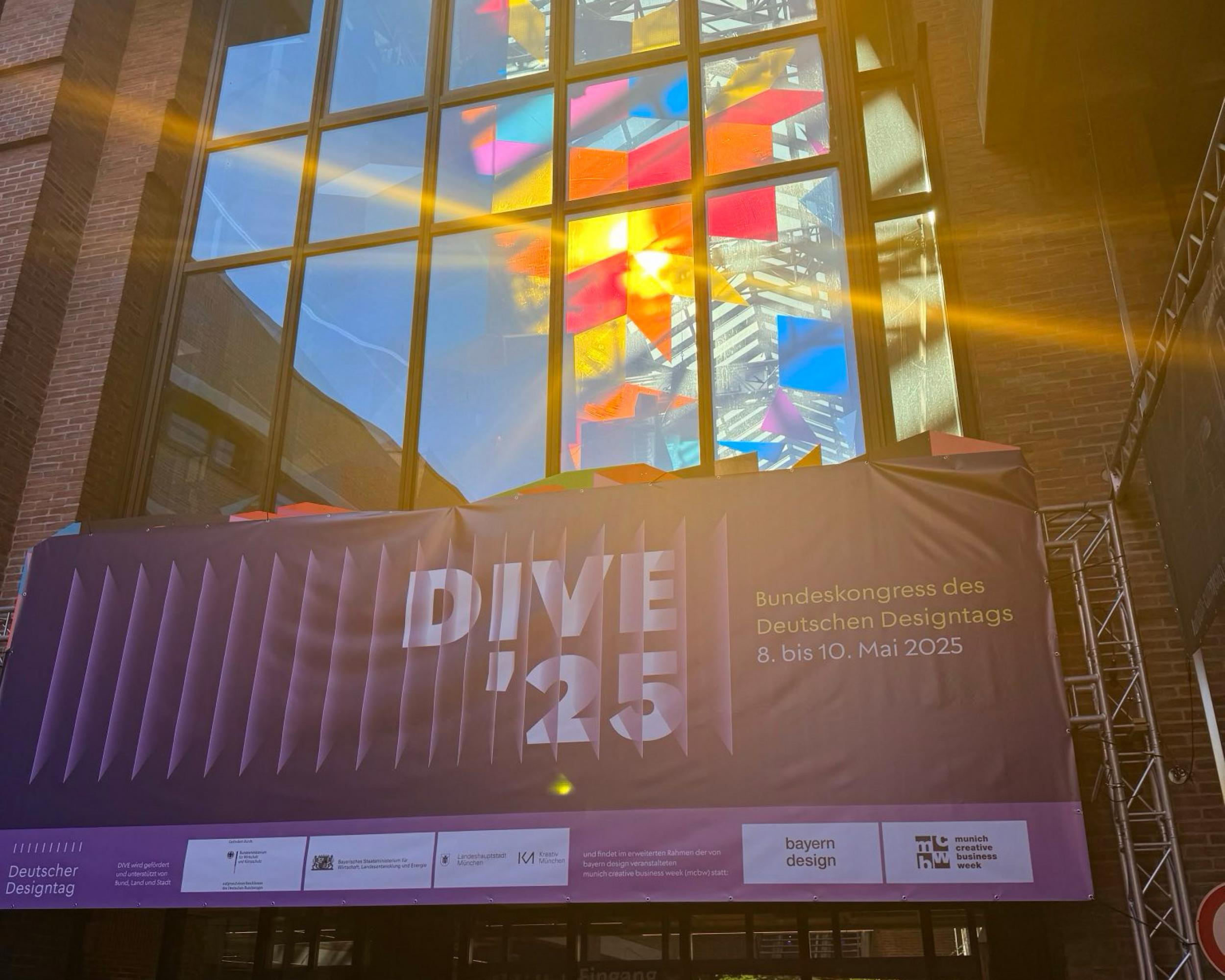 Sonne scheint durch bunte Fenster über dem Eingang zum FatCat in München, Veranstaltungsort der DIVE