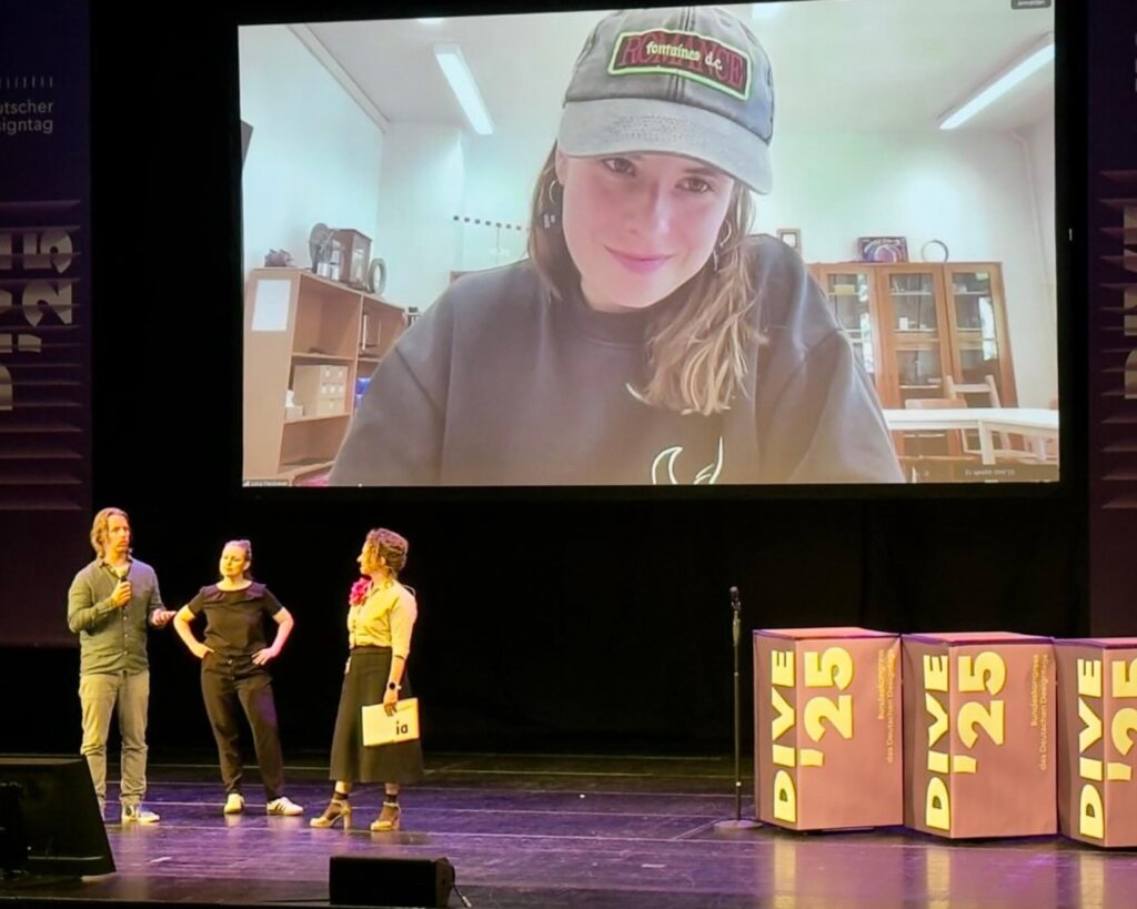 Luisa Neubauer auf der großen Leinwnad über der Bühne. Auf der Bühne stehen Stefan Bergmeier, Bettina Otto und Julia Peglow.